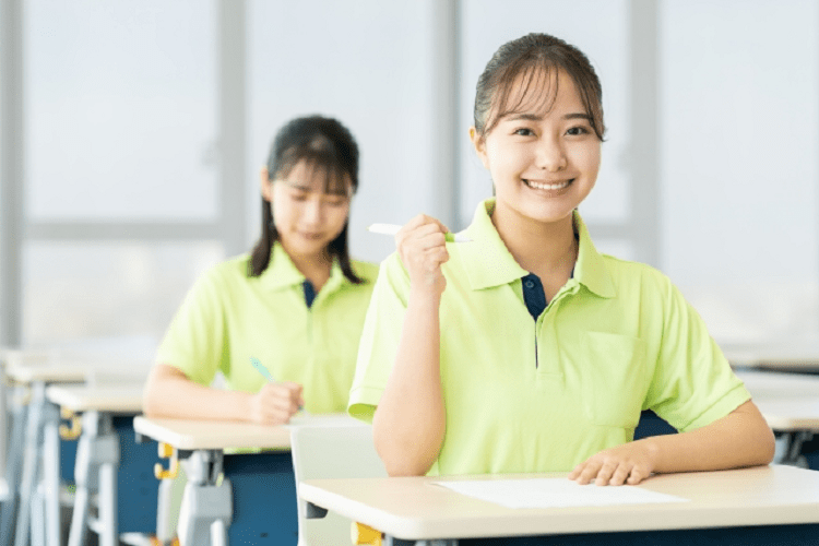教室で勉強しガッツポーズをしている介護士