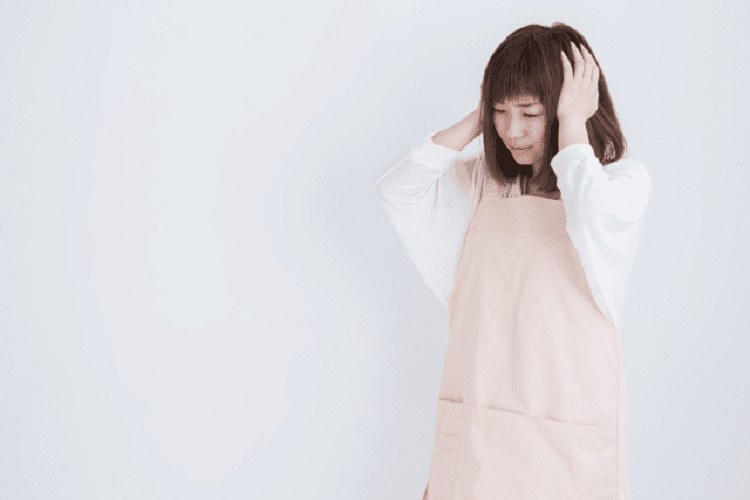 頭を抱え悩む女性介護士