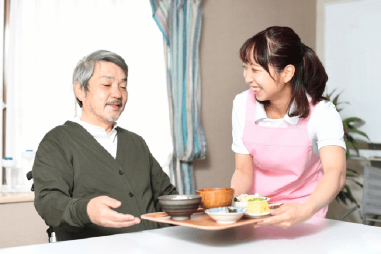 食事を配膳する笑顔の女性介護士