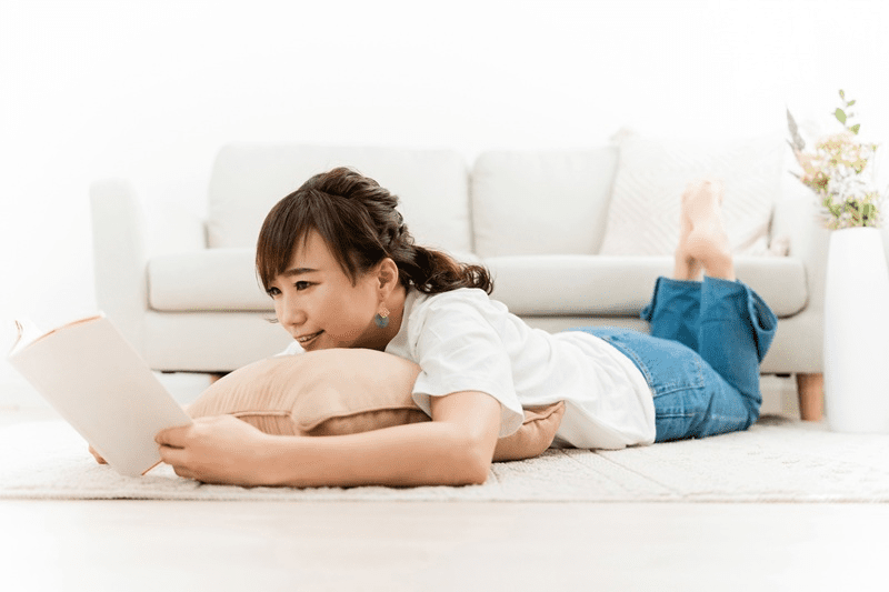 寝転がって漫画を読む女性