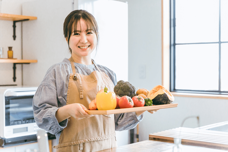 食材を抱えてほほ笑む女性