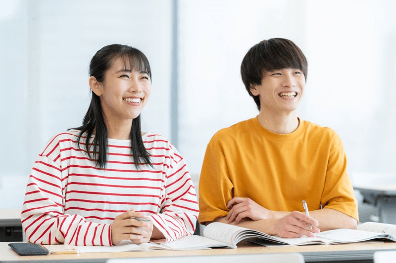 笑顔で勉強する男女の大学生