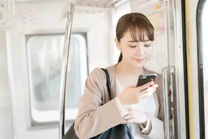 電車内でスマートフォンを操作する女性
